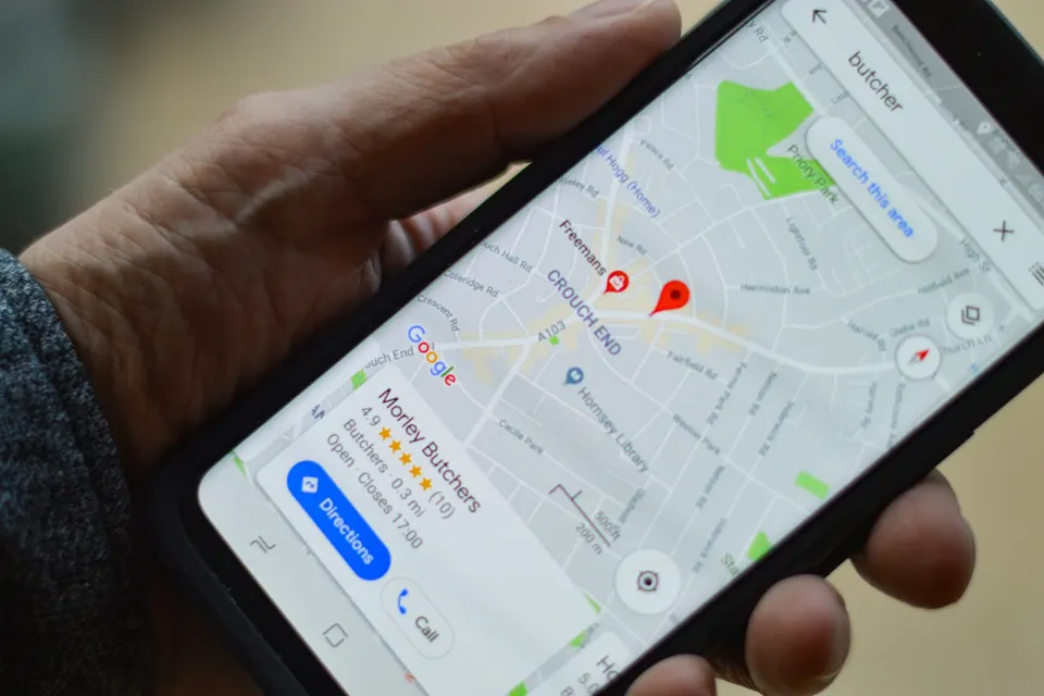 Persona que sostiene un teléfono móvil negro con la pantalla encendida